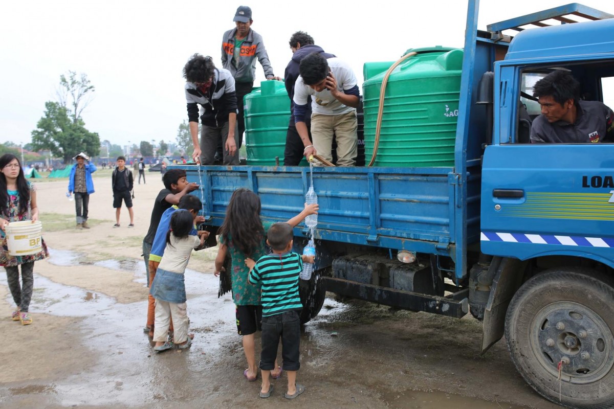 On 28 April, children, some filling water bottles, get drinking water from workers in a truck, during a distribution in a camp for people displaced by the massive earthquake, in Kathmandu, the capital.

On 28 April 2015 in Nepal, search, rescue and relief operations continue in the aftermath of the massive 7.8 magnitude earthquake that hit the country on 25 April. The quakes epicentre was 80 kilometres from Kathmandu, the capital. At least 3,351 people have been killed, 6,833 have been injured, and 8 million people in 39 districts have been affected. The Government has declared a state of emergency in 35 affected districts in the country, where more than 1.3 million people  over half of whom are children  are affected by the disaster. Homes and vital infrastructure, including hospitals, have been severely damaged or destroyed, leaving thousands of children and families homeless, vulnerable and in urgent need of food, shelter, safe water and sanitation, and health support. Over 1.4 million people are in need of food assistance. Most of the displaced are sheltering in camps or in available open spaces. The situation has been exacerbated by continuing powerful aftershocks that have caused additional damage. Working with the Government and other partners, including fellow United Nations organizations, UNICEF is supporting water, sanitation and hygiene (WASH), health, nutrition, child protection, education and other interventions. In response to the disaster, UNICEF is providing hospitals tents, tarpaulin sheeting, emergency medical kits, vaccines and related supplies, zinc and oral rehydration salts to prevent diarrhoeal disease outbreaks, and temporary learning spaces and psychosocial counselling for children. UNICEF is also procuring emergency health kits and is supporting water trucking services in camps for the displaced.