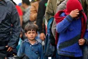 On 10 September, a young boy and an older child stand among other people who have fled their homes amid the ongoing refugee and migrant crisis, on a rainy day in the town of Gevgelija, on the border with Greece. In late August 2015 in the former Yugoslav Republic of Macedonia, more than 52,000 people have been registered at the border by police in the town of Gevgelija, after entering from Greece, since June 2015. Since July 2015, the rate of refugees and migrants transiting through the country has increased to approximately 2,000 to 3000 people per day. Women and children now account for nearly one third of arrivals. An estimated 12 per cent of the women are pregnant. Many are escaping conflict and insecurity in their home countries of Afghanistan, Iraq, Pakistan and the Syrian Arab Republic. There are children of all ages traveling with their families. Some are unaccompanied minors aged 1618 years who are traveling in groups with friends. They are arriving in the country from Greece, transiting to Serbia and further to Hungary, from where they generally aim to reach other countries in the European Union.