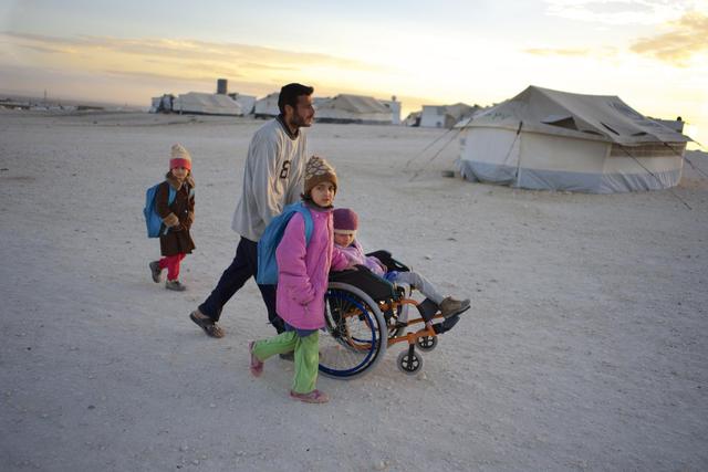 On 26 November 2013 in Jordan, Ahmed pushes his daughter Safa, 6, to school in a wheelchair, in the Zaatari refugee camp, in Mafraq Governorate, near the Syrian border. Two of Safas sisters are nearby. After the familys home in the Syrian city of Aleppo was destroyed, Safa, her parents, grandmother and five siblings fled to rural Damascus. While sheltering in an abandoned farmhouse, the family was caught in an attack that left Safa gravely injured  she lost her right leg and suffered burns and shrapnel wounds. She and her family now live in Zaatari, where Safa attends school in the mornings, goes to a child-friendly space in the afternoons and also regularly receives physiotherapy. I love my girls so much, says Ahmed. Im not with any side. Whats the fault of our daughters? Theyre not guilty. Why would this happen? As the Syrian crisis enters its fourth year, needs are escalating at an increasingly urgent pace, with children bearing the greatest toll. Since March 2011, over 7,000 children have lost their lives in the violence, while hundreds of thousands have been wounded, some of whom must now live with life-long disabilities caused by their injuries. By mid-December 2013, the conflict had left 6.5 million people displaced internally. They are among 9.3 million people inside the country in need of humanitarian assistance, of whom 46 per cent are children. Fighting has also forced over 2.2 million people to seek refuge abroad. The majority have fled to Egypt (130,524 refugees); Iraq (210,612); Jordan (568,501); Lebanon (787,886); and Turkey (553,281). The decimation of medical facilities, immunization and cold chain systems, and water, sanitation and hygiene infrastructure has jeopardized childrens health and markedly increased their vulnerability to diseases, which spread with greater ease amid mass population movements. In October 2013, cases of wild poliovirus were identified in the Syrian Arab Republic, where the disease ha