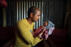 On 26 May, Narayan Krishna Shivakoti holds his crying 22-day-old son, Nirman, in a building in the earthquake-affected town of Singati, near the town of Charikot in Dolakha District, epicentre of the 12 May earthquake. Nirman was born in the period between the first and second earthquakes. Someday, when we look back, we won't remember this as a time of loss or earthquakes, but as when our first baby was born. And he is a healthy baby," Mr. Shivakoti said. He and his wife (Durga Shivakoti) lived about a kilometre from the quakes epicentre. Their home was destroyed and their poultry farm was damaged during the second disaster. UNICEF and partners are providing shelter, hygiene and nutrition supplies across quake-affected areas of the country. In late May 2015 in Nepal, recovery efforts continued following the 7.8-magnitude quake that struck on 25 April and the 7.3-magnitude quake that struck on 12 May. As of 27 May, more than 8,670 people have been killed and 21,933 people have been injured in the disaster. In the 14 districts hardest hit, 2.8 million people, including 1.1 million children, have been affected. Residences, schools and vital infrastructure, including hospitals, have also been severely damaged or destroyed in the disaster, leaving children and families homeless, vulnerable to disease outbreaks and in urgent need of food, shelter, safe water and sanitation, and health, protection and education support. UNICEF, working with the Government and other partners, is supporting efforts across vital sectors, including water, sanitation and hygiene (WASH), nutrition, health, child protection and education. By 20 May, UNICEF had reached approximately 305,109 people with water interventions and provided 45,201 people with access to sanitation and handwashing facilities and 225,585 people with hygiene education and related materials. Additionally, 122 child-friendly spaces have now been set up for displaced communities in eight districts, benefiting 12,200 a