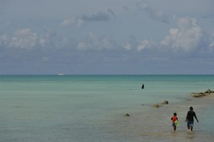 A boy and his father walk with their fishing gear into the Pacific Ocean near Tarawa, the capital. In late 2006 in the Republic of Kiribati, childrens quality of life is declining, as it is across the region. Kiribati is one of 14 Pacific Island Countries, which form a group of atolls dispersed over 30 million square kilometres of the Pacific Ocean. Because populations are scattered across multiple islands, efficient delivery of health care, education and other social services is difficult. The region is also vulnerable to natural disasters like floods, typhoons and volcanic eruptions. While overall infant and under-five mortality rates have declined since 1990, some countries, including Kiribati, lag behind in improving child health and access to basic services. Across the region, birth registration systems are weak or fragmented. Sixty per cent of Pacific children are anaemic, and deficiencies in Vitamin A, iodine and other micronutrients are common. Immunization rates are declining in many nations, partly due to the challenge of maintaining the cold chain in remote islands. Some 20 per cent of Pacific Islanders have no access to improved drinking water, while 30 per cent lack sanitation facilities. Poverty forces many children to drop out of school, and while HIV/AIDS infection rates are low, unsafe sex practices and lack of knowledge prevail. Increases in teen pregnancies, drug and alcohol abuse, domestic and sexual violence and child trafficking are contributing to an overall decline in living standards for children and women. UNICEF and its partners are working with health ministries to improve birth registration practices and other child health initiates; deliver psychosocial support to children and families affected by natural disasters and political conflicts; and raise awareness among young people of HIV/AIDS and its prevention. UNICEF is also providing assistance throughout the region in the areas of immunization; child and maternal health; water and sanitation; and education.