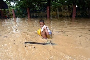 A boy carries supplies through waist-high floodwater in Pasig City in Manila, the capital.  On 30 September 2009 in the Philippines, over half a million people are displaced by flooding caused by Tropical Storm Ketsana (also known as Ondoy), which struck on 26 September. The storm dumped over a months worth of rain on the island of Luzon in only 12 hours. The flooding has affected some 1.8 million people, and the death toll has climbed to 246; both numbers are expected to rise as aid workers reach additional disaster areas. The Government has declared a state of calamity in Metropolitan Manila  the capital city with a population of over 15 million  and 25 other provinces. Power outages and mud-choked roads are slowing rescue efforts, and shelters report shortages of food, medicine and other essential supplies. Stagnant floodwater poses disease and sanitation hazards, and two other tropical storms are approaching the country, complicating relief efforts. UNICEF has responded by distributing hygiene kits, essential medicines, water purification tablets, portable toilets, blankets and soap, and is collaborating with the relief efforts of other UN agencies. UNICEF is also working to address the long-term needs of affected children by providing psychosocial support and planning for the rehabilitation of damaged schools.