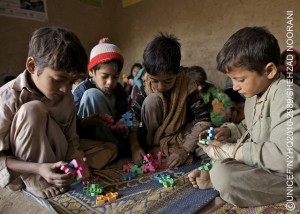 Ten-year-old Khairzada Zaman (right) and other boys play with blocks in a UNICEF-supported child protection centre in Ghaniabad Village of Dera Ismail Khan District, Khyber-Pakhtunkhwa Province. Khairzada wears a cloth bandage over his broken hand. I was home when water came, he said about the floods. It was about 4 p.m. We had to leave immediately, leaving everything behind Water destroyed everything, even my textbooks. My school uniform is rotten. Later, when we came back, there was a lot of mud around. I slipped and broke my hand. Khairzada now lives in a tent with his parents and seven siblings. By the end of January 2011, the people of Pakistan continue to struggle with the effects of the worst flooding in their countrys recorded history. The flooding began in mid-July 2010 and, at its height, affected 20 million people, half of them children. An estimated 170,000 people remain displaced in camps and spontaneous settlements, primarily in Sindh Province, but all four provinces and the Federally Administered Tribal Areas face difficult recoveries. Millions have returned to ruined homes and damaged infrastructure, with recovery and rebuilding costs estimated at US$8-10 billion. Six months after the crisis began, a joint nutrition survey conducted by the Government and aid agencies, including UNICEF, has revealed that malnutrition rates for children under five far exceed critical levels: the rate of severe acute malnutrition, a deadly condition, stands at 6.1 per cent in northern Sindh, and the provinces global acute malnutrition rates are between 21 and 23 per cent. Forty per cent of households lost entire food stocks, and over 2 million hectares of crops were destroyed, leaving over 5.7 million people food insecure. In Khyber-Pakhtunkhwa Province, 650,000 people are displaced by civil conflict and unable to return due to winter conditions. They are further threatened by landmines that have been moved by floodwaters. From the start, UNICEF has joined the government, other UN agencies and partner NGOs in responding to this unprecedented emergency. UNICEF is supporting: the supply of drinking water to 3.5 million people daily, and sanitation facilities to more 1.9 million; the provision of services for 120,000 malnourished children and women in feeding centres; the immunization of 9 million children against measles and polio; and the creation of temporary learning centres for 180,000 children, and child-friendly centres for 200,000 children. UNICEF has appealed for US$251 million to fund its emergency response, of which US$198 million has been received or pledged  leaving a US$52 million gap still needed to meet vital child rights concerns.