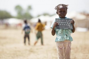 A girl holds a slate after leaving school as she stands in the Toukra IDP site in N'Djamena, Chad on Monday October 22, 2012.  UNICEF UK - local copies saved here: Y:Key-initiativesIFSahel-Stories-2012Chadphotos only_W