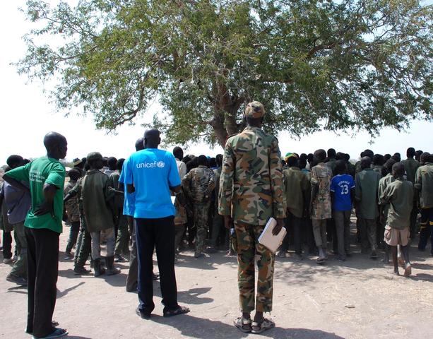 On 27 January, children leave a ceremony formalizing their release from the SSDA Cobra Faction armed group, in the village of Gumuruk, Jonglei State. Earlier that day, the children surrendered their weapons and uniforms in a UNICEF-supported ceremony overseen by the South Sudan National Disarmament, Demobilization and Reintegration Commission and the Cobra Faction. The T-shirt of a UNICEF worker bears the UNICEF logo.

On 27 January 2015 in South Sudan, UNICEF and partners secured the release of approximately 3,000 children associated with an armed group, in one of the largest-ever such releases of children. The first group of 280 children were released today in the village of Gumuruk, Jonglei State. Releases of additional children will occur over the coming month. Recruited by the South Sudan Democratic Army (SSDA) Cobra Faction, the children range in age from 11 to 17 years. Some have been fighting for up to four years, and many have never attended school. In the last year, 12,000 children, mostly boys, have been recruited and used as soldiers by armed forces and groups in South Sudan as a whole. The newly released children are being supported with basic health care, protection services and necessities such as food, water and clothing to help them prepare to return to their families. Counselling and other psychological support programmes are urgently being established. The children will soon have access to education and skills training. UNICEF is working to trace and reunify the children with their families, a daunting task in a country where more than 1 million children have either been displaced internally or have fled to neighbouring countries since fighting broke out in December 2013. Support will extend to local communities to prevent and reduce discrimination against the returning children and also to prevent possible recruitment. UNICEF estimates the costs for the release and reintegration of each child is approximately US$2,330 for 24 months. To date, UN