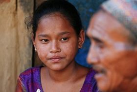 On 3 June 2015, Anjali Darain, 13, listens to her grandfather Dil Bahadur Darain speak about his son, daughter-in-law and grandson, who died during the April 25 earthquake in Salyantar Village Development Committee in Dhading, one of the earthquake-affected districts in Nepal