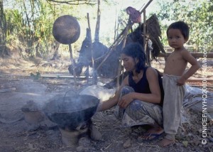 Accompanied by a toddler, a woman stokes a cooking fire in a village in the south-eastern province of Svay Rieng.  In 2000 in Cambodia, after more than a decade of intermittent peace, the country is continuing its recovery from 30 years of conflict, including genocide. Despite progress in health and nutrition, maternal and infant mortality rates are the highest in south-east Asia, most of the predominantly rural population still lacks access to essential services, and problems of ongoing violence, displacement and landmines continue to take their toll. HIV/AIDS is spreading rapidly, accelerated by a growing commercial sex industry, with an estimated 35 per cent of sex workers under 18 years of age, almost half of whom are presumed to be HIV positive. With half of the country's population under 18 years of age, these indicators represent a major threat to their future, including increased rates of mother-to-child transmission. UNICEF programmes to help combat the spread of HIV/AIDS include support for prevention and awareness programmes to all social sectors, including student-to-student education exchanges, the provision of testing and counselling services, and improved access to recovery and care for affected children and families.