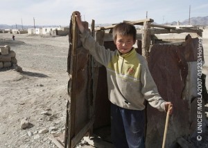 Unnamed boy waks from a ramshackle shared latrine that is in poor condition. Not a UNICEF project. This is an area inhabited by Kazakh families that have a very different set of traditions to most Mongolians. UNICEF is working with local authoriities to expand itís presence in the are to assist remote communities as part of the CBSS programme, this includes increased access to better services and schools. Bayan Ulgii Aimag centre, western Mongolia, 2007.