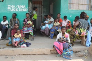 [RELEASE OBTAINED] Patients wait outside the Samfya Stage 2 Clinic, in the rural town of Samfya, in Samfya District. The clinic provides PMTCT services as well as other child and maternal health services. In October 2010 in Zambia, clinics in both urban and rural areas are providing vital programmes to treat HIV-positive pregnant women and to prevent mother-to-child transmission of HIV (PMTCT). PMTCT programmes include HIV testing during pregnancy, antiretroviral (ARV) regimens for sick HIV-positive pregnant women, and early diagnosis and treatment for infants exposed to HIV in utero. These infants receive prophylactic antibiotics and ARVs in the weeks after they are born and are administered HIV tests at six weeks. If breastfed by an HIV-positive mother, infants continue to receive prophylactics and are tested again at 12 months and 18 months (and three months after breastfeeding ceases or at any age if they fall ill). HIV-positive infants diagnosed and treated within the first 12 weeks of life are 75 per cent less likely to die from the disease. However, many infants do not receive PMTCT services because their caregivers lack access to properly equipped facilities or fear the stigma associated with HIV. Zambia has recently made great strides in expanding PMTCT programmes. In the second quarter of 2009, ARVs were administered to approximately half of all children in need and to some 57 per cent of HIV-positive pregnant women. But for PMTCT measures to be effective, infants must adhere to a long-term, structured course of tests and services. Access to PMTCT services is particularly difficult in rural areas, where poverty rates are higher and many remote communities have limited access to health clinics. UNICEF supports the expansion of these services into rural areas, including Samfya District in Luapula Province. The province has the highest child-mortality rates in the country, and Samfyas clinics face critical staff and supply shortages. However, rural areas also tend to have lower HIV infection rates, as well as greater willingness on the part of fathers to participate in PMTCT services.