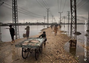 On 13 September, a boy pushes a cart along a narrow strip of land between utility poles and expanses of flood water, in the city of Hyderabad, Sindh Province. By 26 September 2011 in Pakistan, over 5.4 million people including 2.7 million children had been affected by monsoon rains and flooding, and this number was expected to rise. In Sindh Province, 824,000 people have been displaced and at least 248 killed. Many government schools have been turned into temporary shelters, and countless water sources have been contaminated. More than 1.8 million people are living in makeshift camps without proper sanitation or access to safe drinking water. Over 70 per cent of standing crops and nearly 14,000 livestock have been destroyed in affected areas, where 80 per cent of the population relies on agriculture for food and income. Affected communities are also threatened by measles, acute watery diarrhoea, hepatitis and other communicable diseases. The crisis comes one year after the countrys 2010 monsoon-related flooding disaster, which covered up to one fifth of the country in flood water and affected more than 18 million people, half of them children. Many families are still recovering from the earlier emergency, which aggravated levels of chronic malnutrition and adversely affected primary school attendance, sanitation access and other child protection issues. In response to this latest crisis, UNICEF is working with Government authorities and United Nations agencies and partners to provide relief. Thus far, UNICEF-supported programmes have immunized over 153,000 children and 14,000 women; provided nutritional screenings and treatments benefiting over 2,000 children; provided daily safe drinking water to 106,700 people; and constructed 400 latrines benefiting 35,000 people. Still, additional nutrition support and safe water and sanitation services are urgently needed. A joint United Nations Rapid Response Plan seeks US$356.7 million to address the needs of affected populations over the next six months. Only US$9 million has been received so far.