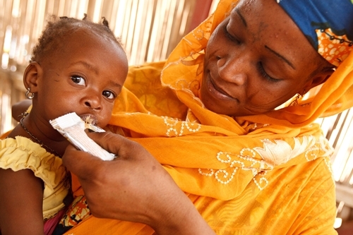 A woman feeds ready-to-use therapeutic food to her malnourished daughter, at the UNICEF-supported Routgouna Health Centre, in the town of Mirriah, Mirriah Department, Zinder Region.