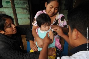(Centre) Irma Irene Yat Chú, an indigenous Mayan woman, holds her 1-year-old daughter, Lisbeth Gabriela, at home in the community of Chivencorral in Cobán Municipality, in Alta Verapaz Department. Volunteer health workers from a community health centre, (left-right) Laura de Jesús Icoó Pop and Mario Cucul, prepare a measles vaccine for Lisbeth. The centre, run by the Ministry of Health with support from UNICEF, serves a population of 3,476 and is open twice a week. Through home visits, volunteer health workers provide routine health care and immunizations for pregnant women and children under age 5 who are unable to travel to the health centre. [#6 IN SEQUENCE OF EIGHT] In November 2012 in Guatemala, the Government and other partners are continuing to assure sustained routine immunization of children  now reaching 92 per cent of all infants  against a range of vaccine-preventable diseases. The countrys last endemic case of measles was in 1997. In the entire Americas Region (covering North, Central and South America), the last endemic measles case was in 2002 and the last endemic case of rubella was in 2009  part of global efforts to eradicate these diseases. Worldwide, measles remains a leading cause of death among young children: In 2010, an estimated 139,300 people  mainly children under the age of 5  died from the disease. Nevertheless, these deaths decreased by 71 per cent from 2001 to 2011, thanks in part to the Measles & Rubella Initiative, a global partnership led by the American Red Cross, the United Nations Foundation, the United States Centers for Disease Control and Prevention (CDC), WHO and UNICEF. In Guatemala, despite this success, significant other challenges for children remain, much of it related to poverty levels that affect more than half of all children and adolescents. Poverty also contributes to chronic malnutrition affecting half of all under-5 children (with higher rates among indigenous populations); an average national education level of under six years of primary school (under three years for the rural poor); and high, though decreasing, rates of violence. Guatemala is also one of the worlds most vulnerable countries to climate change, suffering a major climate-related emergency every year since 2008. On the positive side, birth registration is improving, with more than 95 per cent of newborns now being registered. UNICEF is working with the Government and other partners to sustain achievements in health, address the high levels of malnutrition, strengthen responses to crimes against children and increase protection services for children throughout public services.