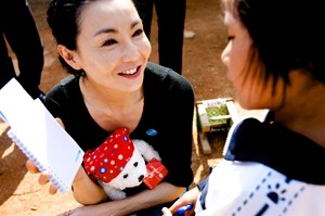 UNICEF Goodwill Ambassador Maggie Cheung gives a teddy bear and notebook to a girl who is HIV-positive, in Ruili City, Yunnan Province. The teddy bear and notebook display the UNICEF logo.  In April 2010 in China, acclaimed international actress and newly appointed UNICEF Goodwill Ambassador (China) Maggie Cheung visited children and women affected by HIV/AIDS in Ruili City, in the south-western province of Yunnan. Although China has relatively low rates of HIV infection, the risk of transmission is significantly higher in parts of Yunnan Province, which borders major opium producing regions in neighbouring countries. HIV prevalence is 0.1 per cent nationally, but rises to 20 per cent among intravenous drug users in Yunnan. The disease remains highly stigmatized and poorly understood by much of the population, factors that could accelerate the spread of the epidemic, particularly among the rural poor, migrants, sex workers and injecting drug users. On 29 April, Ms. Cheung was appointed a UNICEF Goodwill Ambassador to advocate on behalf of vulnerable children, including those affected by HIV/AIDS and disability. Her visit to Yunnan aimed to raise awareness of HIV/AIDS and to mitigate stigma associated with the disease. By the end of 2007, an estimated 700,000 Chinese were HIV-positive.