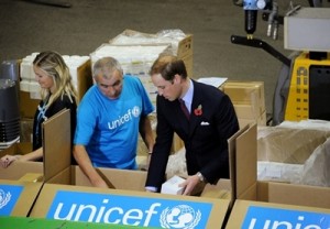 The Duke of Camidge (R) helps UNICEF warehouse worker Peter Jones (L) to pack emergency health kits, ready to be sent to East Africa.   2. November 2011, UNICEF Supply Division, Copenhagen   The Duke and Duchess of Camidge (William and Catherine) accompanied by the Crown Prince and Crown Princess of Denmark (Frederik and Mary) made a special visit to the UNICEF global supply centre in Copenhagen to help maintain the world’s attention on the humanitarian crisis in East Africa, which has left more than 320,000 children so severely malnourished that they are at imminent risk of death unless they get urgent help.   UNICEF’s supply centre includes a warehouse the size of three football pitches where essential supplies for children around the globe are sourced, packed and distributed. These include food, water, special nutritional supplies for the most malnourished children, vaccines, education materials and emergency medical kits.   Whilst at the supply centre both couples were iefed on the desperate situation in the region by UNICEF specialists. The royal couples then joined UNICEF warehouse staff on packing line, and helped to pack emergency health kits, ready to be sent to East Africa. Each kit will provide life-saving supplies to over 1000 people.   The Duke and Duchess and the Crown Prince and Princess then toured the warehouse, seeing the huge variety of supplies that are sent to emergencies around the world, including ready-to-use therapeutic food for severely malnourished children under five years old and supplementary food to support-families, emergency health kits, vaccines and water supplies including water purification tablets.   At the end of their visit the Duke of Camidge said “An incredible amount is being done. UNICEF is leading the way and doing a fantastic job, but sadly there’s lots more still to do, and that’s why we’re here today”   To donate to UNICEF East Africa Appeal please visit www.eastafricacrisis.org