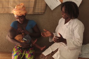(Left-right) A woman learns how to correctly hold and breastfeed her child, with help from Nurse Pascaline Bandre, at Rapadama Traditional Health Centre in the village of Rapadama in Plateau-Central Region. In partnership with the NGO Association Chant de Femmes (ACF), UNICEF supports the work of community health workers, who discuss issues related to health and nutrition with local communities. When Nurse Bandre arrived at the centre four years ago, 10 to 15 malnourished children were ought in each week. 