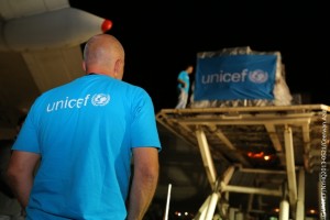 On 1 September, a UNICEF worker observes as cargo, part of 100 tonnes of emergency supplies, is unloaded from a plane that has just arrived in the city of Erbil, Kurdistan Region. The supplies were urgently airlifted from UNICEFs global supply warehouse in Copenhagen, Denmark, in response to the growing needs of the estimated 200,000 Syrian refugees now in Iraq. The workers T-shirt as well as a tarpaulin affixed to the cargo bear the UNICEF logo. On 1 September 2013 in Iraq, a plane carrying 100 tonnes of UNICEF emergency supplies for Syrian refugee children and their families arrived in the city of Erbil. The supplies were urgently airlifted from UNICEFs global supply warehouse in Copenhagen, Denmark, to respond to the growing needs of the estimated 200,000 Syrian refugees now in Iraq. Delivered supplies include water tanks, tap stands, latrine equipment, water purification tablets and testing kits; oral rehydration solution; emergency health and hygiene, early childhood development, and recreation kits; school materials; and temporary schools and safe spaces. The provision of most of the supplies was made possible by a US$5.8 million contribution from the Government of Kuwait as well as an in-kind contribution from UPS, a UNICEF partner, which provided support toward the cost of airlifting the goods. Inside Syria, the war continues to escalate and has displaced some 4.25 million people. In addition to Iraq, Syrians also continue to flee to neighbouring Jordan, Lebanon and Turkey, and as far away as Egypt. By 3 September, the total number of Syrian refugees had surpassed 2 million. One million of them are children. Working with diverse governments, partners and other United Nations agencies, UNICEF has appealed for a total of US$470.65 million to cover responses within Syria and all host countries. By 22 August, nearly 60 per cent had been funded.