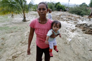 A mother carries her daughter as they evacuate from the typhoon hit town of Laur, Nueva Ecija province, Monday, October 19, 2015. Typhoon Koppu smashed in the Northern Philippines causing widespread damages to properties and crops as well displacing thousands of people.Ê Ê