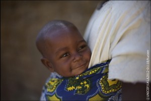 Niger, November 2012. Haouaou Abdou, 52, mother of 6 children is carries her youngest son, is Issiakou, 8 months, in the village of Mazadou Abdou.   By Jessica Mony  In 2011, droughts across the Sahel plunged millions of families into a food crisis. A year after UNICEF and partners emergency response began, we ask ourselves how can we stop this vulnerability and persistent cycle of suffering? A poor, rural Nigerien village 600 people may hold the answer. Here, despite every familys struggle during the drought, no child suffered malnutrition in 2012.  Just three years ago it was rare for a week to go by without a child dying from combinations of malnutrition, diarrhoea and malaria in Mazadou Abdou village. During the frequent droughts, at times this would rise to two or three. No family was spared the pain of loss and mourning. Haouoau and Loli Abdou are just one set of parents that faced this tragedy. Loli holds up three fingers and lists that in 2000, 2002 and then again in 2004 they lost three children to malaria. Looking solemnly at their healthy 8 month baby boy Issiakou, it is clear the scars will likely never heal for this family. Sadly, their situation is not unique in this or any other village across the Sahel.  Fortunately, in 2008 a simple UNICEF programme of family practices helped change all of this. The practices are simple and include exclusive breastfeeding for the first six months of life; complementary feeding for children after six months; proper hand-washing techniques; treatment of diarrhoea; knowledge of how to seek medical care; immunisation; using mosquito nets to prevent malaria; promotion of delayed pregnancies and girls education. The results of adhering to these practices for the children of Mazadou Abdou have been significant. Moutari Louali, a community volunteer who is helping to implement the programme explains the impact. Before the programme started, around four to five children would die every month from malaria, diarrhoea and other diseases. Now, during the whole of this year only three children died, and this was because of miscarriages. From the chief through to parents and children themselves, the whole village is determined that no child should die from preventable diseases. Haouaou is clearly proud of the result In this village we didnt have any malnutrition because we take care of our children. I am very happy about how healthy our children are.   At the heart of the programme are volunteers like Moutari who, along with two other volunteers selected by the community, ensure that every family implements the practices and monitors progress. Every week the group visit up to five families to run information sessions. Today, Moutari is visiting Hoauoaus household. Starting with an update on the health of their children, Moutari then calls a mother and her child forward to demonstrate a particular practice. Today its the use of mosquito nets and hand washing. Everyone here comes to listen and learn. Haouaou points at two of her daughters who were born before and after the programme started and she learnt about the benefits of exclusive breastfeeding. Look you can see this one is much stronger. Whilst drought, hunger and vulnerability are an ongoing reality for these families, their efforts to implement the programme are the key to ensuring their children not only survive, but are resilient through times of drought and extreme hardship.   Issa Iahim the 63 year old chief of Mazadou Abdou describes the precarious situation many families across the Sahel live in. In this village our life is based around farming. The difficulty of this life is that if the rainy season doesnt give a good harvest, life becomes extremely difficult for us. For now the health of their children is safe, but the challenges ahead for the village are immense. A community run cereal bank will help tide them over for a while, but after this the only other option for many families is for husbands and fathers to head to Nigeria to search for work. Haouaou has thirty bowls of millet to feed her family until the harvest a year away. It will only last a month. She holds out the bowl and laughs nervously. What can we do?    Whilst Mazadou Abdous families continue to walk a tightrope of vulnerability, their newfound knowledge will keep their children alive and healthy. It is not the whole solution, but it provides the hope of a future for their most precious resource, their children. The Chief is thankful for how far they have come. We are very proud and happy for what we have done here. We thank God, we thank the people who taught us these practices, but he is also conscious of the toll of chronic hunger on the future of this community; If a man is hungry he cannot hear, he cannot learn anything.  The impact of the emergency response across the Sahel can be seen in the short term in the lives saved and the malnutrition prevented. For vulnerable families like Haouaous though, building resilience and food security will be key to long term change. This village has demonstrated the success of community driven initiatives to improve childrens health, but more support is needed to ensure communities across the Sahel are able to withstand crises. Haouaou tries not to think about what might happen a year from now; Nobody can forsee the future. Even if we wait and hope for the best, anything can happen at any moment.  UK Natcom - for local copies of the files: Y:Key-initiativesIFSahel-Stories-2012Niger