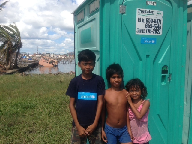 Good sanitation arrives in Tacloban with the distribution of UNICEF Portalets today outside the Tacloban Astrodome, location of some of the worst devastation in Tacloban (as can be seen in the background). Good sanitation prevents disease and saves lives.