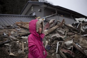 On 15 March, Neena Sasaki, 5, surveys the wreckage of her home, which was destroyed by the 11 March tsunami, in Rikuzen-Takaata, a small town in Iwate Prefecture. Her family has returned to their home to salvage some belongings. The town suffered thousands of fatalities; relief workers ran out of body bags during recovery operations. By 24 March 2011 in Japan, aftershocks continue in areas affected by the 9.0-magnitude earthquake and subsequent tsunami that devastated the northeast coast on 11 March. The confirmed death toll stands at 9,408, and 14,716 people remain missing. The quake and tsunami have also damaged the Fukushima Daiichi and Daini nuclear power plants, giving rise to a nuclear emergency. Both plants suffered explosions, and the Fukushima Daiichi plant has experienced dangerous radiation leaks, causing widespread radioactive contamination of vegetables, tap water and milk. Some 261,000 people remain in evacuation centres, down from almost a half million people on 16 March. Over 83,000 of evacuees are from communities near the damaged Fukushima power plants. Some 90 per cent of telecommunications has been restored, but 216,000 households remain without power, and 760,000 are without water. The Government has initiated construction of temporary housing and is assessing the number of children orphaned by the disaster. The United Nations Office for the Coordination of Humanitarian Affairs (OCHA) is assisting the Governments response, and UNICEF has deployed logistics teams. The Japan Committee for UNICEF has ordered early childhood development kits, schools-in-a-box, and recreation kits for distribution to children affected by the emergency. The International Atomic Energy Agency is coordinating international support for the Governments management of the nuclear crisis.