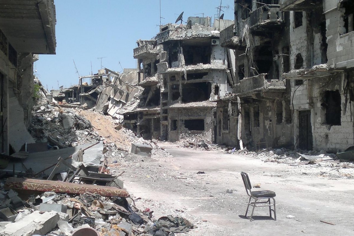 On 17 May, a chair sits in the centre of a desolate street, which is covered in rubble and lined with destroyed buildings, in the Old City area of Homs, the capital of Homs Governorate.

In mid-May 2014 in the Syrian Arab Republic, displaced residents returned to the Old City area of Homs, the capital of Homs Governorate, to survey damage to their homes and businesses. The return followed the evacuation of rebels from Old City, the result of an agreement negotiated between the fighters and the Government. The now-devastated Homs has borne some of the heaviest and most prolonged fighting of the conflict. Across the Syrian Arab Republic, some 9.3 million people, including nearly 4.3 million children, have been affected by the conflict. Of those affected, over 6.5 million have been internally displaced. More than 2.7 million Syrians, 1.4 million of them children, have fled abroad  to nearby Egypt, Iraq, Jordan, Lebanon and Turkey  where they are registered or awaiting registration as refugees.