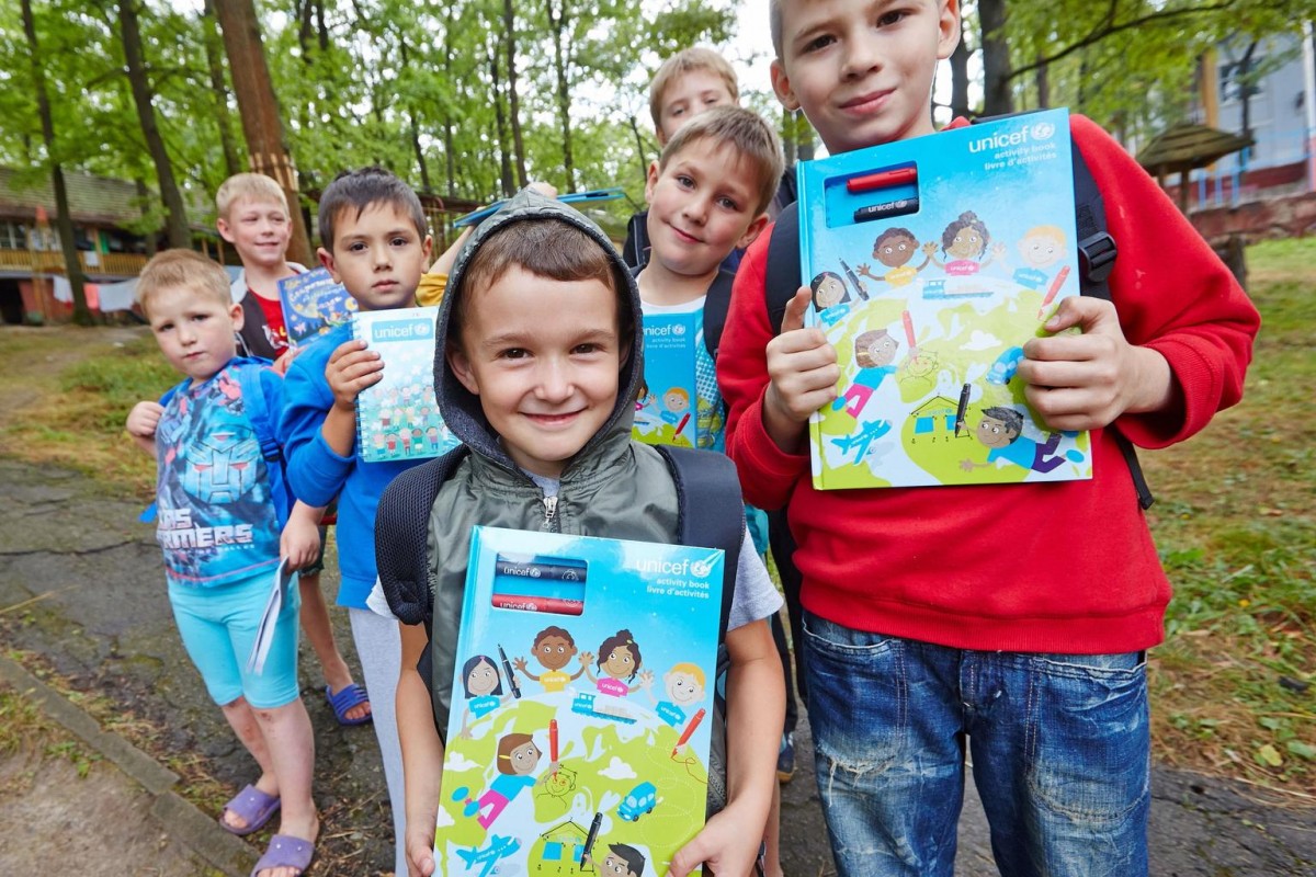 On 27 August, children hold books and other supplies from their new UNICEF school kits, at the Romashka accommodation centre where they now live, on the outskirts of the city of Kharkiv in Kharkiv Oblast Province. The centre provides shelter for people displaced by the countrys continuing conflict. The UNICEF logo is visible on most of the childrens books. UNICEF is distributing school kits (consisting of backpacks filled with basic school supplies) to displaced children in accommodation centres, in preparation for the upcoming school year.

By 13 October 2014 in Ukraine, at least 3,682 people had been killed and 8,871 had been wounded in the countrys continuing conflict. More than 402,000 people have also been internally displaced, and an estimated 5.1 million people are living in conflict-affected areas. Over 427,000 people have also sought refuge in neighbouring countries. The fighting has destroyed or disrupted essential infrastructure and basic services, leaving affected populations vulnerable and in need of urgent support. Ongoing insecurity and a lack of safe access are also hampering the provision of humanitarian aid. Despite the current ceasefire, serious ceasefire violations continue to be reported daily, and shelling has intensified in areas in Donetsk and Luhansk oblasts  two of the five provinces most affected by the conflict. In response to the continuing fighting, UNICEF is supporting health, nutrition, water, sanitation and hygiene (WASH), education, and child protection interventions, including: the provision of vaccines and essential medicines; the distribution of drinking water and ongoing water treatment to provide safe water; the delivery of child and adult hygiene kits, early childhood development (ECD) kits and school kits; and the establishment of child-friendly spaces to provide psychosocial support for children affected by the conflict.