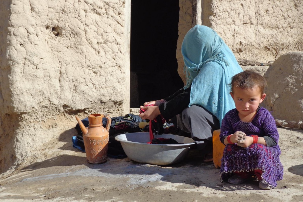 On 29 October 2015 in Afghanistan, Gul Chahra, 30, washes clothes outside as her daughter Khalesa, 3, sits beside her Kashaktan village, Farkhar district, northern Takhar Province.  Many families have been forced to live outdoors.  As freezing temperatures set in, families must rebuild as fast as possible.

A 7.5 magnitude earthquake struck Afghanistan and Pakistan on 26 October 2015, leaving a trail of destruction and death.  As more information is collected from remote areas, the death toll is rising.  As of 28 October 2015, the death toll stands at over 250, with close to 1,900 persons injured.  Nearly half of them are children.  Over 16,000 homes and 230 schools have been damaged.  Aid delivery and social services are hampered by damages to road infrastructure.