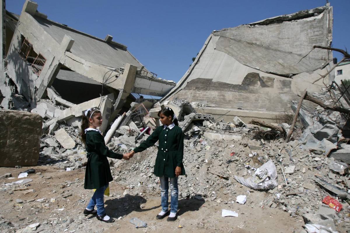 On 16 September, Shaima, 10, and a classmate hold hands while standing beside rubble from a destroyed part of Shujeiyah Girls School in Shujaiyeh neighbourhood in eastern Gaza City. Ten days into the recent escalation of violence between Israel and Gaza, her family moved to her grandfathers ground-floor apartment, which was thought to be a safer place. Early morning, the shelling got closer, Shaima says. Suddenly a bomb fell nearby. Everyone ran out, except for my father and younger sister. I heard people scream that he was dead. Her father, Adel, was on the sofa in the living room with her 2-year-old sister, Dima, in his arms, trying to rock her to sleep, when a shell struck the neighbours house. Both Adel and Dima were killed by shrapnel that came bursting through the walls. I saw my uncle carrying my sister, Shaima recalls. I realized her head was cut off in the shelling. I didnt look at my fathers body, because I was afraid his wounds were as bad. I ran away. Now she is visited regularly by a counsellor from the Palestinian Centre for Democracy and Conflict Resolution (PCDCR), a UNICEF partner that specializes in child trauma. The counsellor sees her at home and helps her talk about her experience. I was not able to say goodbye to my dad, Shaima tells the counsellor. I dont want to be an orphan; I want my dad to be with me. I only have wonderful memories of him. He used to buy me toys, even if I did not ask for them. I wish I could see him and my sister Dima again. I used to play with her. I liked to dress her and comb her hair.

In September 2014 in the State of Palestine, children continue to recover from 50 days of intense violence that engulfed the territory during July and August. The conflict  which ended with a ceasefire on August 26  left 506 children dead and more than 3,000 injured, while destroying an estimated 18,000 houses in Gaza.
