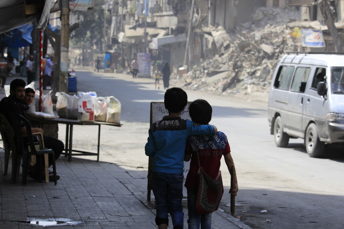 On 24 August 2016 in the Syrian Arab Republic, two children walk arm in arm down a war damaged street in Aleppo.By end August 2016, children continue to bear the brunt of the latest surge in violence in Aleppo.  In the eastern part of Aleppo, around 100,000 children remain trapped since early July.  Water has ceased flowing through the public network, as the generator that operates the main water pumping station needs urgent repairs.  UNICEF does not have safe access to provide the urgent humanitarian assistance needed in the area.In the western part of Aleppo, an estimated 35,000 people were displaced when new waves of fighting hit the al-Hamadaniyah neighbourhood.  Already displaced by the war and living in half-built apartment towers, again families had to flee and leave everything behind.  Most families are currently staying in informal shelters such as schools and mosques as well as in parks and on the streets.  UNICEF trucks in water daily for 300,000 of the most vulnerable people including newly displaced families in informal shelters. The main electricity network that powers pumping stations sustained damage in recent fighting. UNICEF supports the delivery of fuel to operate generators for water pumping stations and groundwater wells that provide safe drinking water to around 1.2 million people.