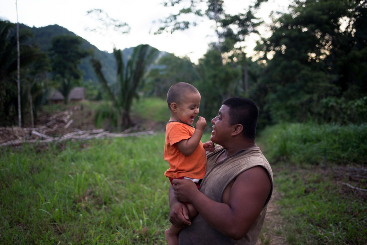 On 15 August 2016 in Belize, 2-year-old Abner laughs while being carried by his father, James Choc, outdoors on their familys plot of land, in San Felipe Village in the Toledo region. The family, which consists of Abners parents, grandparents and aunt  participates in the Roving Caregivers Programme (RCP), which brings services to vulnerable families in the region, especially those living in distant and hard-to-reach locations. Just 50 per cent of villages in the remote, predominately Mayan communities in the Toledo region have access to preschool or day-care services for their children. With many caregivers  including Abners parents and grandfather  working on plantations or construction sites, young children are at risk of missing out on stimulating interaction, a key element for their development. The UNICEF-supported programme, targets children up to age three who have no access to formal early childhood education. RCP facilitators (known as Roving Caregivers or Rovers), who are trained members of the local community, conduct 45-minute home outreach with each of the families they serve, engaging children in age-appropriate stimulating activities through play and encouraging parents and caregivers to participate. They also encourage positive parenting behaviour; and promote behaviour change to address inappropriate parenting practices The 22 Rovers in the RCP programme conduct 45-minute outreach visits with each family. My favourite part of my childrens lives was when they were young and playing without worry; they were laughing and smiling and growing, said Abners grandmother, Maria Choc (not pictured), a mother of 13.

In recent years, considerable progress was made in the area of Early Childhood Development. In 2011 only 32 per cent of children between 36 and 59 months of age attended an Early Childhood Education (ECE) programme, but this reached 55 per cent by 2015. Disparities however persist as only one in five of the p