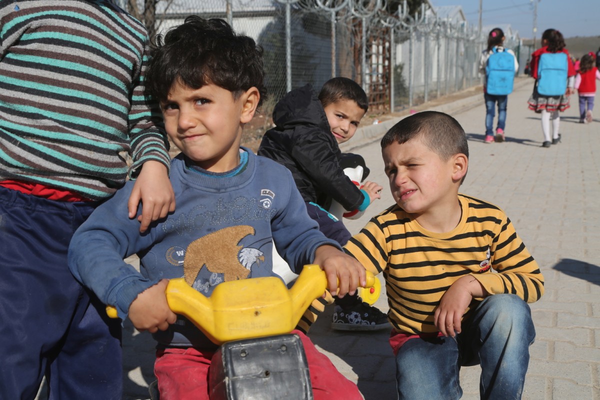 On 16 January 2017, boys racing their tricycles in Nizip 1 refugee camp, Gaziantep, southern Turkey. Nizip 1 camp is home to over 10,000 Syrian refugees, including more than 5,000 children. Since the beginning of the Syria conflict, nearly 5 million people have become refugees, including 2.2 million children. With 1.2 million Syrian refugee children, Turkey has the highest number of child refugees in the world.

In January 2017, over 40 per cent of Syrian refugee children in Turkey missing out on education, despite massive increase in enrolment rates. Nearly half a million Syrian refugee children are currently enrolled in schools across Turkey. But despite a more than 50 per cent increase in enrolment since last June, over 40 per cent of children of school-going age  or 380,000 child refugees  are still missing out on an education.  Turkey is home to more than 1.2 million child refugees, making it the top child refugee hosting country in the world.  In partnership with the Government of Turkey, UNICEF is helping strengthen education systems, increase access to learning and improve the quality of inclusive education for Syrian and vulnerable Turkish children. 

For the first time since the start of the Syrian crisis, there are more Syrian children in Turkey attending class than there are out of school, said UNICEF Deputy Executive Director Justin Forsyth, speaking after a visit to UNICEF programmes in southern Turkey.  Turkey should be commended for this huge achievement. But unless more resources are provided, there is still a very real risk of a lost generation of Syrian children, deprived of the skills they will one day need to rebuild their country.

Since 2013, UNICEF has helped build, renovate or refurnish nearly 400 schools, and trained some 20,000 Syrian volunteer teachers. Approximately 13,000 teachers receive monthly incentives.  Efforts are also under way to include Syrian children in a national programme that grants cash allowanc
