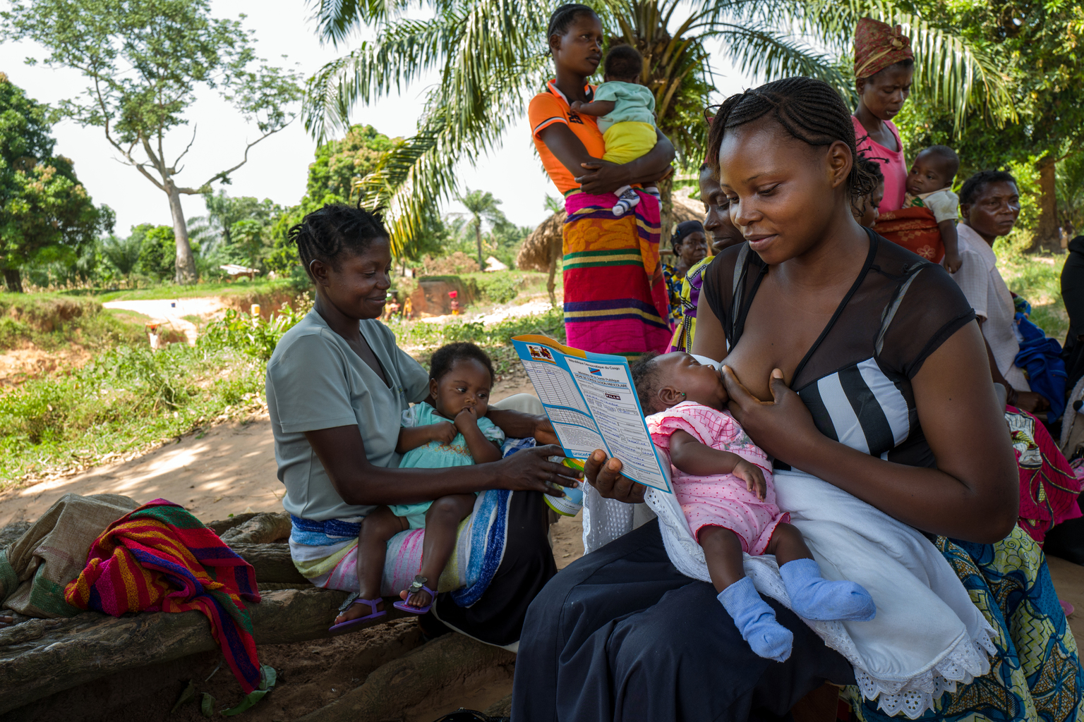 Le 20 mai 2017, une femme lit le carnet de santé de son enfant lors d'une session de vaccination de routine dans un quartier de Kabea Kamwanga, une petite ville située à 70 km au nord-ouest de Mbuji-mayi, en direction de Kananga, dans la province du Kasaï Orientale, au sud de la République démocratique du Congo, une région en proie aux conflits entre les miliciens du chef traditionnel Kamuina Nsapu et les Forces Armées de la République démocratique du Congo (FARDC) depuis juin 2016. / On May 20th, 2017, a woman is reading the health record of her child during a routine immunization session in a neighborhood of Kabea Kamwanga, a small town located 70 km north-west of Mbuji-mayi, in the direction of Kananga, in the province of Kasai Orientale, in the south Of the Democratic Republic of the Congo, a region plagued by conflict between the militia of the traditional leader Kamuina Nsapu and the Armed Forces of the Democratic Republic of the Congo (FARDC) since June 2016. In August 2016, fighting oke out in one of the Democratic Republic of Congos (DRC) poorest regions - Kasai - after a traditional leader was killed in clashes with security forces. The situation deteriorated in 2017, unleashing a wave of violence that has now engulfed nine of the countrys 26 provinces.