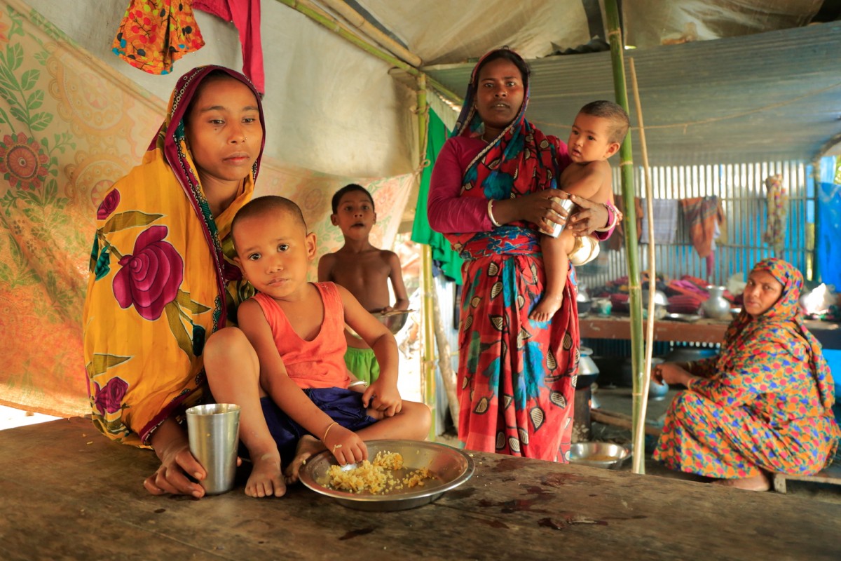 On 17 August 2017, women and children inside the flood shelter in Kurigram District, located in the Rangpur Division, in Northern Bangladesh. Many women are finding it difficult to feed their children and provide safe water.

In August 2017, according to the Ministry of Disaster Management and Relief (MoDMR), an estimated 3.9 million people in 20 districts of Bangladesh have been affected by flooding, the second round of exceptionally heavy monsoon rains to hit the country. Flood barriers have been breached in Saidpur, Lalmonirhat, Dinajpur, Kurigram, Rajshahi and Badarganj. According to the Bangladesh Flood Forecast and Warning Centre (FFWC) 21 rivers are still flowing above the pre-established danger level, and the waters of the Brahmaputra-Jamuna and Ganges-Padma Rivers are still rising. Access to affected areas is challenging, as flooding in the north has made the railway inoperable and roads difficult to navigate, while the runway at Saidpur airport is at risk of being submerged.

As of 14 August, 89 people are known to have died, including at least 14 people in the last 24 hours. 1,392 shelters in flood-affected areas are currently sheltering more than 282,479 people. An estimated 1,000 schools in Districts of Lalmonirhat, Panchagarh, Nilphamari, Kurigram, Gaibandha, Bogra, Jamalpur, Tangail, Sunamganj and Sylhet have closed because they have been flooded or are being used as temporary shelters. An estimated 110,400 hectares of cultivated land have been affected. According to the Department of Public Health Engineering (DPHE), a total of 12,719 tube-wells have been submerged in Kurigram District alone leaving people without easy to access to potable water. Affected children and their families need temporary shelters, access to food and safe drinking water and sanitation.