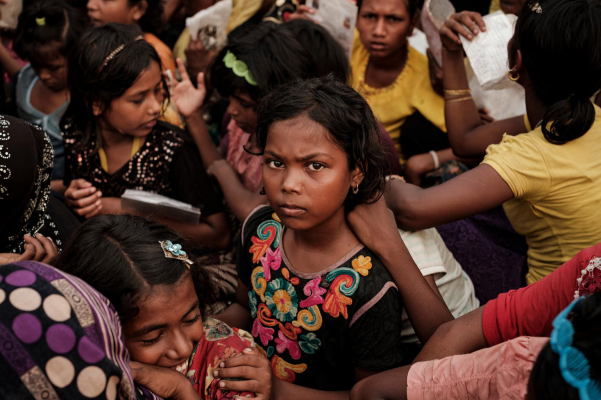 Sufaira, 10, stands among other Rohingya refugees queuing for aid at the Mainnerghona distribution center, Cox's Bazar District, Bangladesh, Friday 17 November 2017. Sufaira is from Londaung, Maungdaw in Myanmar and fled her home with her family when the Myanmar military set fire to it.

The humanitarian situation for Rohingya refugees in Bangladesh remains dire. The influx of Rohingya refugees from northern parts of Myanmar’s Rakhine State into Bangladesh restarted following attacks at Myanmar Border Guard Police posts on 25 August 2017 and as of 23 November 2017, the Inter-Sector Coordination Group (ISCG) reported that 623,000 Rohingya refugees have entered Bangladesh since the attacks. With the new influx, the current total number of Rohingya who have fled from Myanmar into Bangladesh, coupled with the affected population in the communities, has reached a staggering 1.2 million. There are 720,000 children among the new arrivals, existing Rohingya populations and vulnerable host communities who are affected and need urgent humanitarian assistance including critical life-saving interventions.

The inter-agency Humanitarian Response Plan (HRP) for 2017-18 identified the areas of WASH, health, nutrition and food security and shelter for immediate scale-up to save lives in both settlements and host communities. As per the HRP, the Rohingya population in Cox’s Bazar is highly vulnerable, many having experienced severe trauma, and are now living in extremely difficult conditions. The limited WASH facilities in the refugee established settlements, put in place by WASH sector partners including UNICEF prior to the current influx, are over-stretched, with an average of 100 people per latrine. New arrivals also have limited access to bathing facilities, especially women, and urgently require WASH supplies including soap and buckets. Given the current population density and poor sanitation and hygiene conditions, any outbreak of cholera or Acute Watery Diarrhoea (AWD),