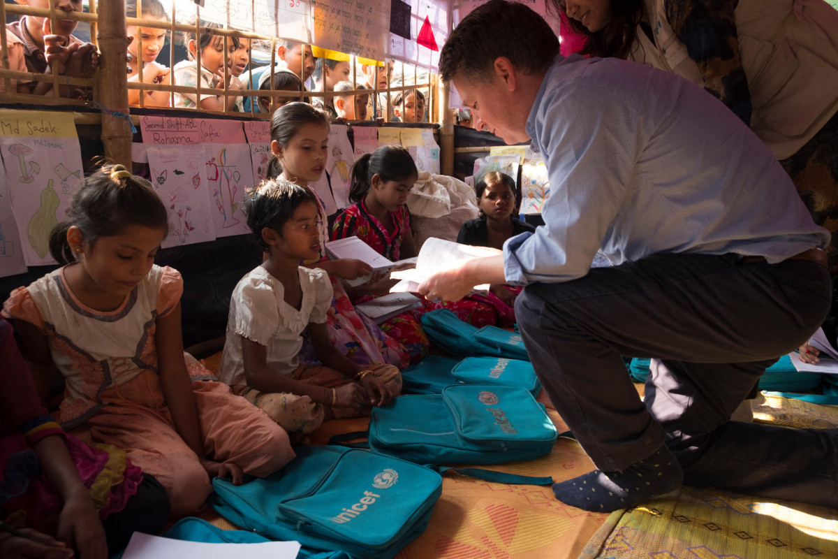 (Right) UNICEF Deputy Executive Director Justin Forsyth meets students at a UNICEF-supported transitional learning centre in the Hakimpara makeshift settlement, Cox's Bazar district, Bangladesh, Thursday 25 January 2018. The transitional learning centre serves Rohingya children who fled violence in Myanmar and are now living in refugee camps in Bangladesh. Children learn English, mathematics, Burmese, sciences, and arts in the learning centres. They also receive psychosocial counselling and are taught hygiene and life skills. Books, pens, colouring pencils, school bags and other educational materials are provided. An estimated 688,000 Rohingya refugees have fled across the border into Bangladesh from Myanmar’s Rakhine State following the outbreak of violence there in late August 2017. More than half of the refugees are children.