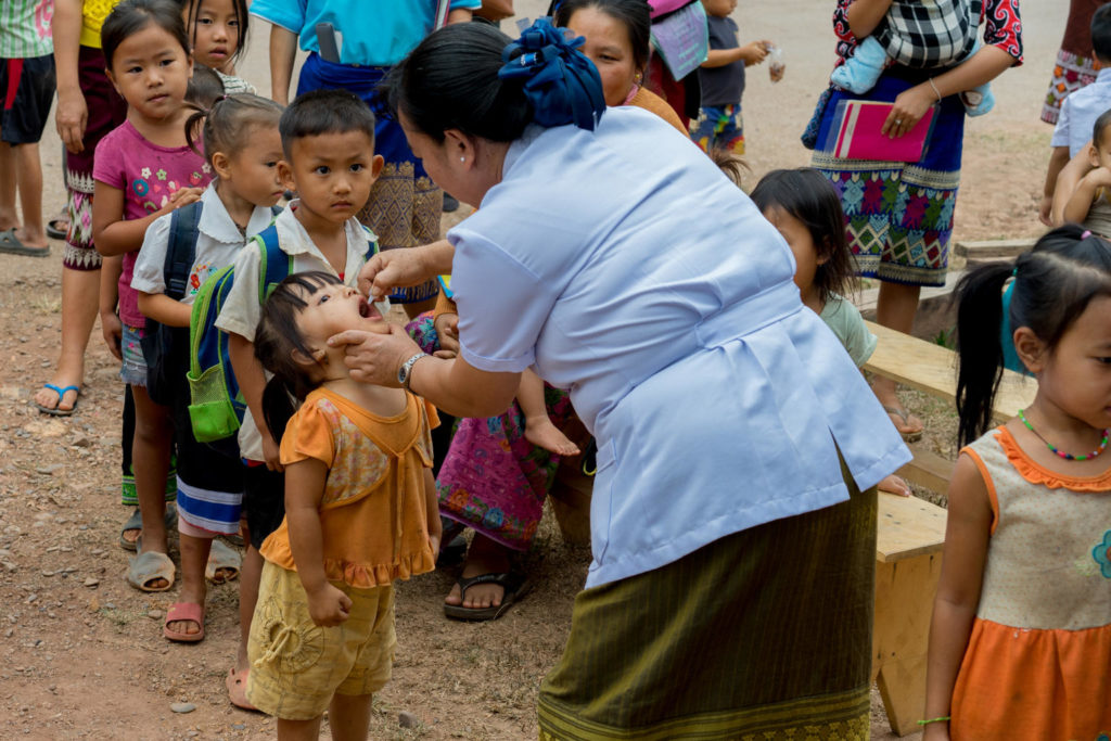 Daeng Xayaseng, Maternal and Child Health Manager, vaccinates children against polio in Nampoung village, Vientiane Province, Lao PDR. A 10-day polio vaccination campaign in 13 provinces in Lao PDR was undertaken in March 2018 to vaccinate about 460,000 at-risk children aged 0 months to 5 years of age. This is in response to a polio outbreak in 2015 and 2016. More than 7,200 volunteers and 1,400 health workers ensured that all children within the 0 to 5 age group in the selected provinces and districts receive the two drops of oral polio vaccine. Children also received routine immunization vaccines. Throughout the campaign period, vaccines will be provided at health centres, as well as district and provincial hospitals, kindergartens, markets and bus stations. Furthermore, there will be outreach sessions, including house-to-house visits to identify and vaccinate children in high-risk areas, and special sessions in rice fields and other plantation areas. As of May 2017, Lao PDR is officially no longer infected with circulating-vaccine derived polio virus type 1 (cVPDV1). After the last outbreak in 2015 and 2016, the country has now been without cases for over 24 months, with the last case reported in January 2016.