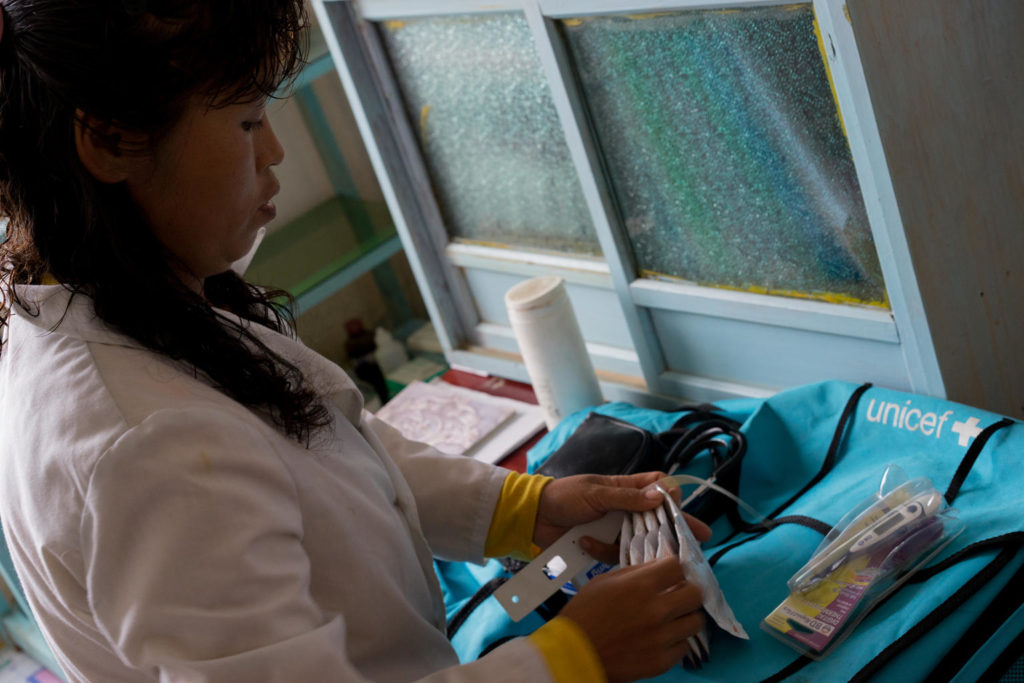 17 May 2018, Hwasan Ri, DPR Korea: For 9 years, Dr. Ri Chol Ok - pictured packing a UNICEF-supported household doctor bag - has been trekking door to door to ing health care to the homes of families in a remote area of DPR Korea. “I cover 122 households, and in a single day I visit 20 to 30 families,” she explains. It’s not an easy job, she says, but thanks to a new bag provided by UNICEF, her work has become a little easier. “The bag is full of essential medical equipment and medicines which we commonly use, like antibiotics and oral rehydration salts (ORS),” says Dr Ri while checking the blue rucksack in preparation for her home visits today. “Before, we mostly used herbal medicines – it’s much better now.” In rural areas like this, children can be particularly vulnerable to diseases and illnesses. Rates of malnutrition and other related problems tend to be higher in rural areas and this year alone six children have been identified in this village. “It’s important to treat children with diarrhoea quickly and this bag allows us to deliver care to children fast,” she says before heading off to begin her shift for the day. “Today I’m first visiting two homes to check on children who had diarrhoea,” she says. “They’ve been treated and should be ok now, but I just want to check their status.” Dr. Ri leaves the clinic and quickly marches down a hill in her boots. It’s a relatively small village of less than 4000 people dispersed across the countryside. The first stop is to the home of 1-and-a-half-year-old Ri Song. “She had diarrhoea for two days and it didn’t stop,” explains her mother while Dr Ri checks the baby’s health. “We were given ORS and zinc tablets and after two days she’s better again.” Globally, diarrhoea is the second leading cause of death for children under five. Without the quick response and right medication provided by Dr Ri Chol Oh, children like young Ri Song would be a great risk.