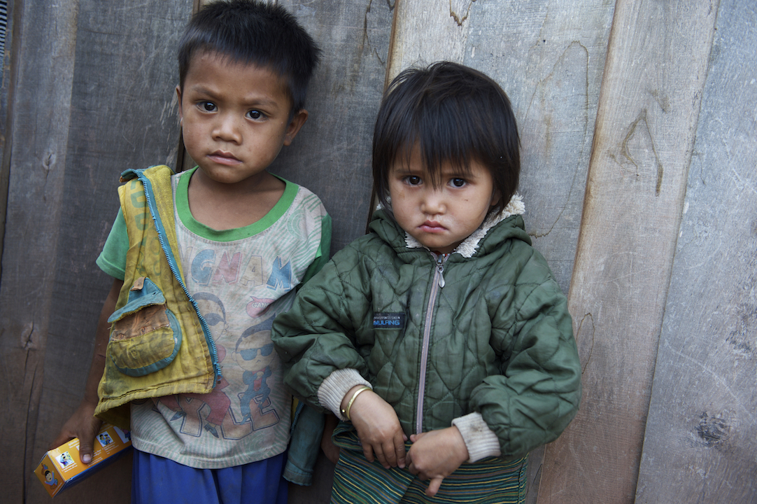 Children stand outside their home in Adone village. Ta Oi district, Saravane province, Lao PDR.