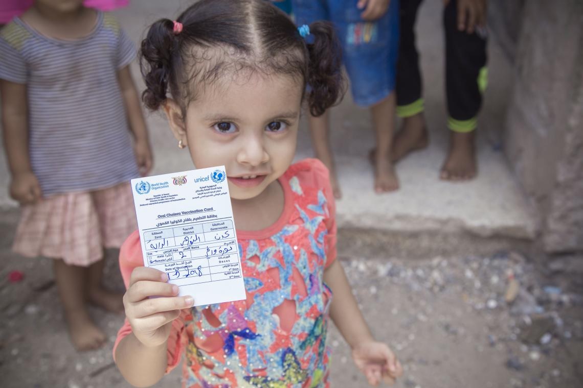 ©UNICEF/UN0209184/Bafaqeh 在2018年5月9日，也門亞丁一個六歲的女孩手持她的疫苗接種卡。在2018年5月，也門在高危地區展開了歷來第一個霍亂疫苗注射運動，以預防世上最嚴重的霍亂疫情死灰復燃。