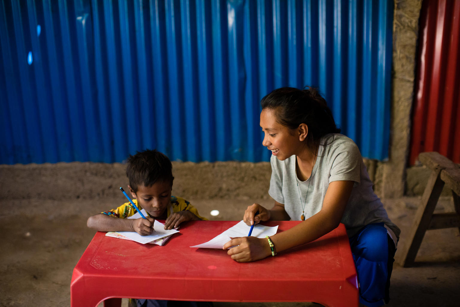 Cidalia M.E da Costa (16) , help her younger brother Januario Viegas da Costa (6) learning at home, in Aileu, Timor-Leste.