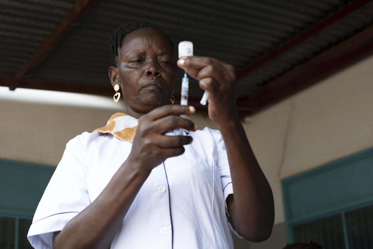 On 24 March 2020, nurse Lillian Nimaya, 45, fills a syringe with a vaccine at Nyakuron Primary Health Care Centre in Juba, South Sudan. Lillian has been working as a nurse for the last five years and conducrs routine immunizations each workday. She says, “We inform the mothers already when they are pregnant that they should vaccinate their children, and we repeat the same message after they have given birth … To ensure the parents are following up, we often ask for the vaccination card when they come to the clinic with their kids for other reasons.” Lillian likes her job, as it allows for her to help people, especially children. “You often hear me saying sorry to the children when I’m giving the jab, that is because I know it hurts. But I also know that this will protect them from dangerous diseases.” Keeping vaccines cold is the hardest part of the job. Lillian says, “We have a fridge here at the clinic, but when we are doing outreach, we have to fill the cool box before we venture out. But as soon as the vaccines are finished or the cooling elements are finished, we have to return to the clinic for more ice or more vaccines. It is a hassle … Another challenge is that this clinic is too crowded, we need more space.”

Due to years of conflict, access constraints, lack of information and misconceptions, South Sudan routine vaccination coverage remains low, at only 44 per cent. UNICEF South Sudan is supporting routine immunization across the country by providing training for vaccinators, procurement and distribution of vaccines and medical supplies such as syringes, as well as the procurement, installation and maintenance of cold chain equipment. UNICEF is also conducting information campaigns to educate caregivers on the importance of vaccinating their children and mobilizing communities leading up to vaccination campaigns.  In 2019, 919,160 children aged 6 months to 15 years were vaccinated against measles and 266,699 of children aged under one r