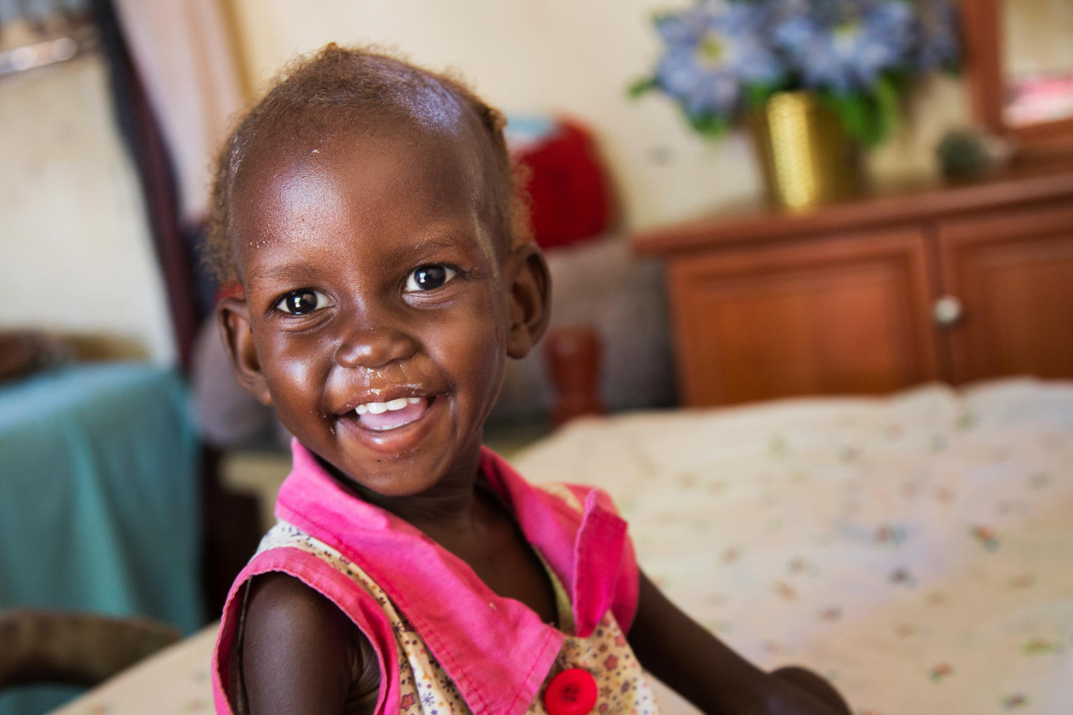 Maria John, 2, who was diagnosed with severe acute malnutrition (SAM), smiles after eating her hourly ration of Plumpy'nut, a peanut-based nutritionally enriched paste used to treat SAM, at her family's home in Juba, South Sudan, Tuesday 14 November 2017.