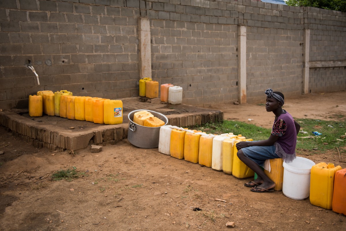 A girl sits at a water tap with a jerry cans lined up in a queue outside a private business on the outskirts of Juba, South Sudan, Friday 17 March 2017. People in this community do not generally have access to clean water, save for that provided by a private business which has fitted a tap providing safe water along the walls of its compound. People queue by leaving their jerry cans until the tap is switched on. Only 41% of children in South Sudan have access to safe, clean water.

A worsening water crisis, fuelled in part by conflict and a deteriorating economy, is just one more challenge families in Juba face on a daily basis. In 2015, an estimated 13 percent of residents had access to municipal water, supplied mainly through a small piped network and boreholes  but this number is likely to have dropped following the violence that hit the city in 2016. For those without municipal access, water is mostly provided through private sector water trucking. Because they draw untreated water straight from the White Nile river, UNICEF, in coordination with the Juba city council, has been providing the trucks with chlorine to treat the water and reduce the spread of deadly waterborne diseases. There are more than 2,000 water tankers in the city, but as running costs continue to rise, so to does the price of water for customers. The lack of safe water means those living in the capital are at huge risk to the spread of deadly waterborne diseases, with children especially vulnerable, exacerbating a growing nutrition crisis. A cholera outbreak which started in Juba in July 2016 has already killed 83 people and infected almost 4,500 others. Many of those who have been affected live in poor neighbourhoods, with little access to safe water and sanitation facilities.