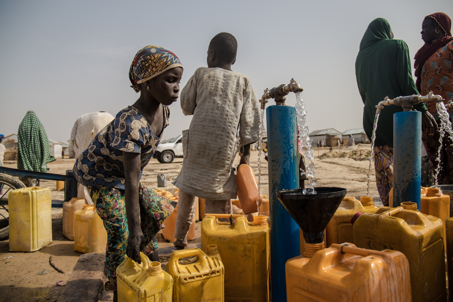 On 13 March 2017, Zara collects water for use at their home in Bakassi IDP camp, in Maiduguri, the capital of Borno State. Four solar powered boreholes with 10,00 litre overhead storage for each borehole and 60 water taps are servicing 21,000 Internally Displaced Persons from Gwoza, Marte, Monguno LGAs. The prolonged humanitarian crisis in the wake of the Boko Haram insurgency has had a devastating impact on food security and nutrition in northeast Nigeria, leading to famine-like conditions in some areas, according to a World Food Programme (WFP) situation report from late February 2017. The United Nations Office for the Coordination of Humanitarian Affairs (OCHA) projects that by June 2017 some 5.1 million people in Nigeria will be food insecure at crisis and emergency levels. In 2017 in northeast Nigeria, in Borno, Adamawa and Yobe, the three states most directly affected by conflict, 75 per cent of water and sanitation infrastructure in conflict-affected areas has been damaged or destroyed, leaving 3.8 million people with no access to safe water. Displaced families are putting enormous pressure on already strained health and water systems in host communities. With the ongoing disruption to basic services the likelihood of waterborne diseases, such as diarrhoea and cholera, is growing and children are worst hit in such conditions leading to increase malnutrition and mortality. One third of the 700 health facilities in the hardest-hit state of Borno have been completely destroyed and a similar number are non-functional. As at 15 March 2017, over the past 12 months, UNICEF and partners have provided safe water to nearly 666,000 people and treated nearly 170,000 children suffering from severe acute malnutrition in the three conflict-affected northeast Nigerian states of Borno, Yobe and Adamawa. As part of cholera preparedness, UNICEF and other WASH Sector partners are building the capacity of government and NGOs on cholera response and developing contingency plan