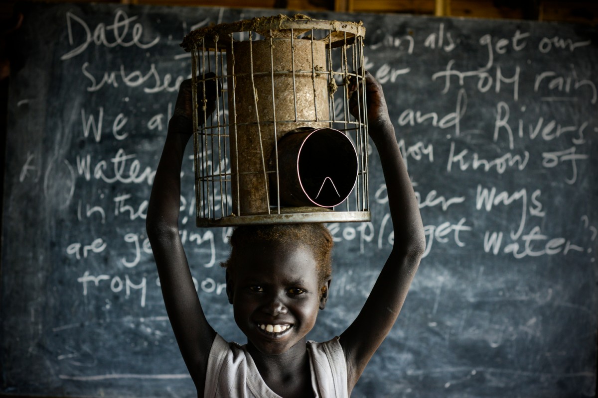 On 15 August 2016 in the Bentiu Protection of Civilians site (POC) in Unity State , Nyaboth, 6, holds her family stove that she carries to school to sit on during class. She says "There is nothing to sit on at school and as soon as I bring the stove home my mother needs it straight away for cooking, she says with a smile. The war brought me and my family here. I saw so many bad men with guns shooting people, I saw so many wounded. It made me very sad, it was so bad and it made me sad. I am very happy at school, my favourite subject is math. I live here in the POC with my mother and I feel safe.

South Sudan has one of the highest proportions of children out of school in the world, that is 1.8 million children with an unclear future. With a low primary enrolment rate, around 40 percent, less than 14 percent complete the 8 year primary cycle. Only 30 per cent of those enrolled are girls and only 1 out of 10 girls complete the primary education cycle. Incidents of children dropping out of school has recently increased due to economic crisis and food insecurity as well as recent violence in Juba and Wau.