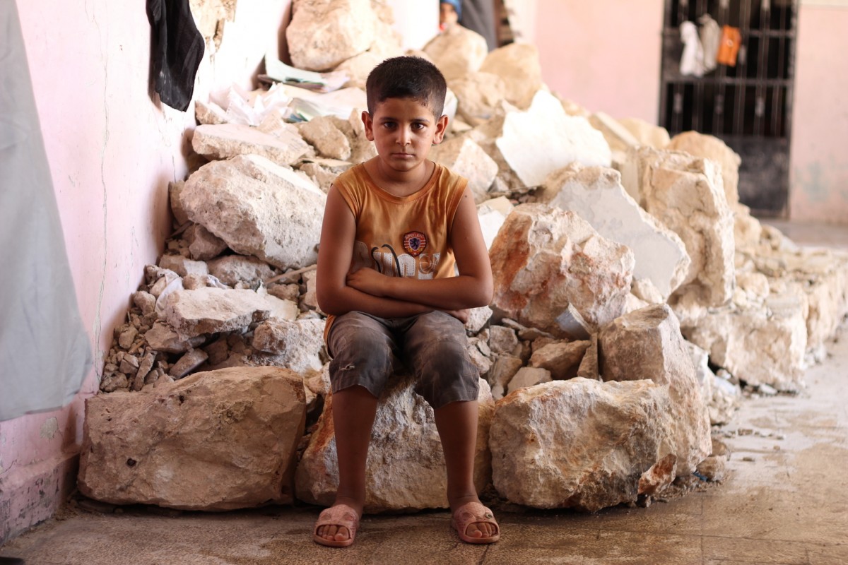 On 12 August 2016 in the Syrian Arab Republic, a displaced child from al-Hamadaniyah neighbourhood  in the western part of Aleppo now stays at a temporary shelter.By end August 2016, children continue to bear the brunt of the latest surge in violence in Aleppo.  In the eastern part of Aleppo, around 100,000 children remain trapped since early July.  Water has ceased flowing through the public network, as the generator that operates the main water pumping station needs urgent repairs.  UNICEF does not have safe access to provide the urgent humanitarian assistance needed in the area.In the western part of Aleppo, an estimated 35,000 people were displaced when new waves of fighting hit the al-Hamadaniyah neighbourhood.  Already displaced by the war and living in half-built apartment towers, again families had to flee and leave everything behind.  Most families are currently staying in informal shelters such as schools and mosques as well as in parks and on the streets.  UNICEF trucks in water daily for 300,000 of the most vulnerable people including newly displaced families in informal shelters. The main electricity network that powers pumping stations sustained damage in recent fighting. UNICEF supports the delivery of fuel to operate generators for water pumping stations and groundwater wells that provide safe drinking water to around 1.2 million people.